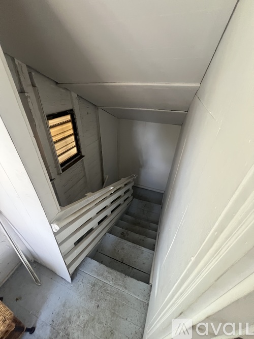A stairway with a window and a wall on the side.