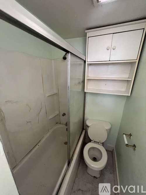 A bathroom with a toilet and a cabinet.