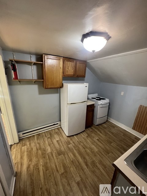 A kitchen with wooden cabinets and a white refrigerator.