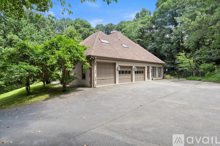 A house with a driveway and trees around it.