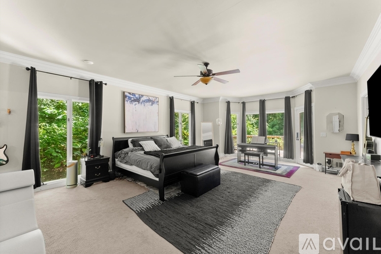 A bedroom with a large bed and a ceiling fan.