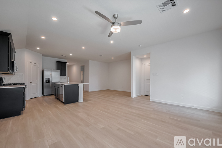 A spacious kitchen with a ceiling fan and lighting fixtures.