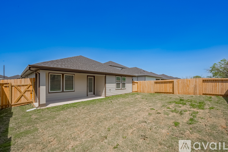 A house with a brown fence and a grassy yard.
