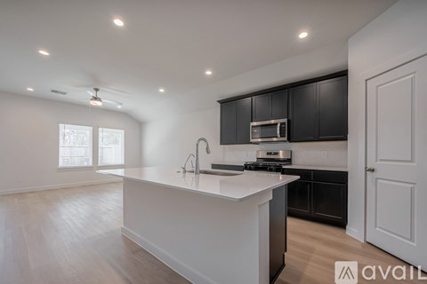 A modern kitchen with black cabinets and a white island.