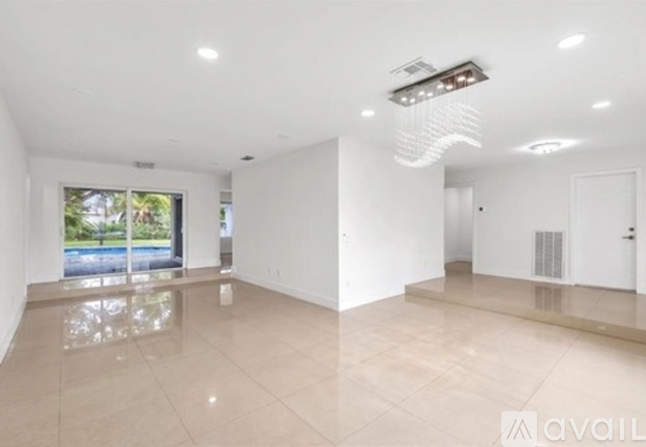 A spacious room with a large window and a white ceiling.