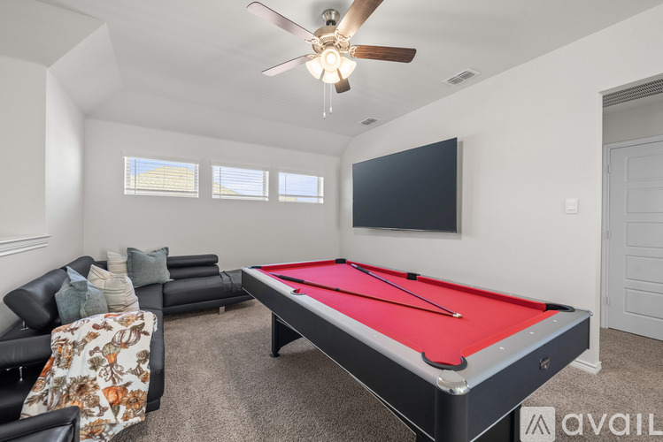 A room with a pool table and a couch.