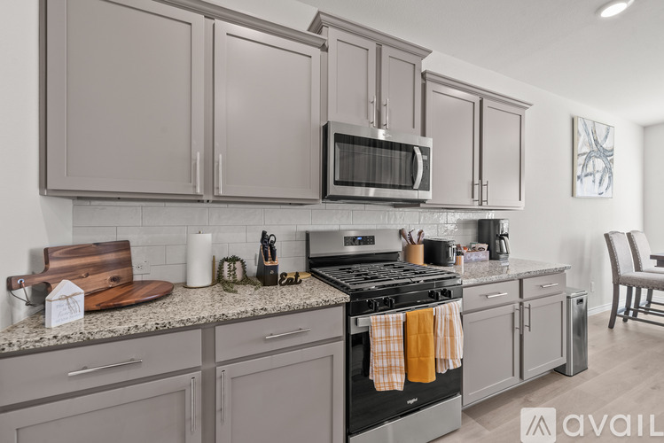 A kitchen with grey cabinets and a black stove top.