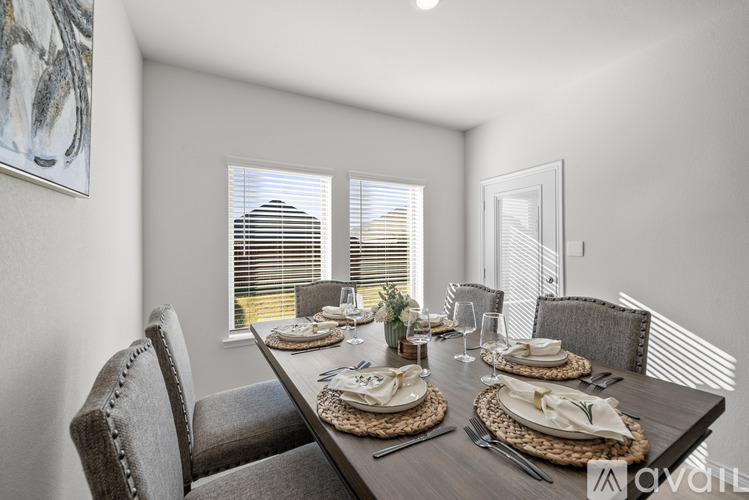 A dining room with a table set for a meal.