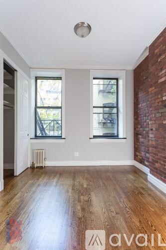 A room with wooden floors and a brick wall.