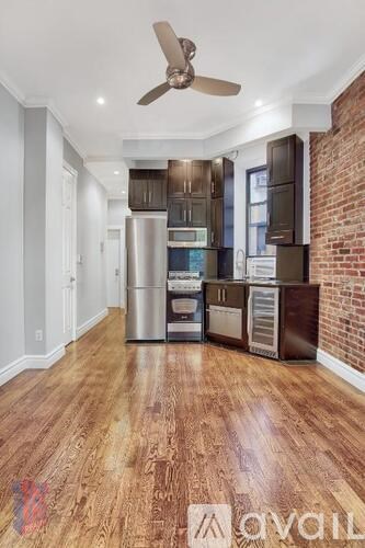 A kitchen with wooden floors and a brick wall.