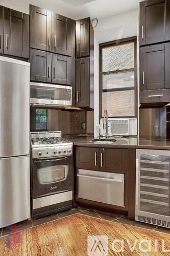 A kitchen with dark wood cabinets and stainless steel appliances.