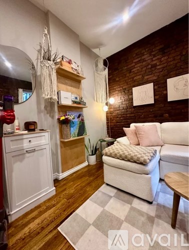A living room with a white couch and a wooden floor.