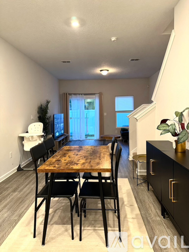 A dining room with a wooden table and chairs.
