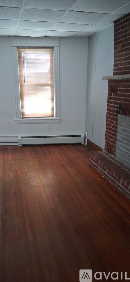 A room with a window and wooden floors.
