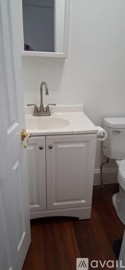 A white bathroom with a sink and toilet.