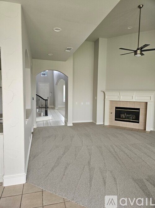 A living room with a fireplace and a fan.
