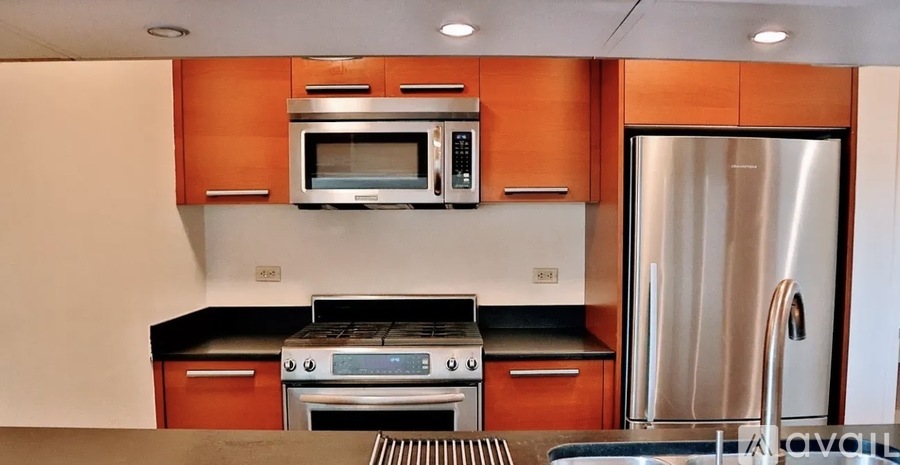 A modern kitchen with a stainless steel refrigerator and wooden cabinets.