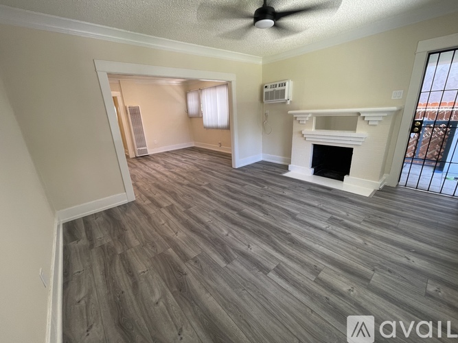 A room with a ceiling fan and a fireplace.