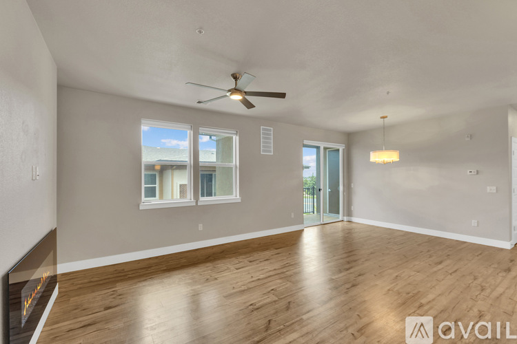 A spacious room with a ceiling fan and wooden flooring.