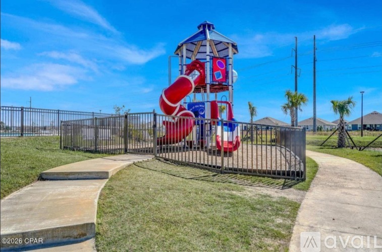 A playground with a red and white slide and a blue and white tower.