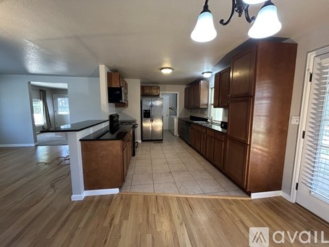 A kitchen with wooden cabinets and a black countertop.