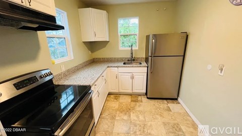 A kitchen with a black stove top oven and a black refrigerator.