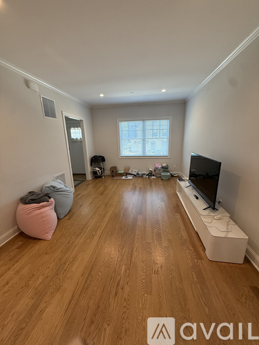 A living room with a television, a couch, and a bean bag chair.