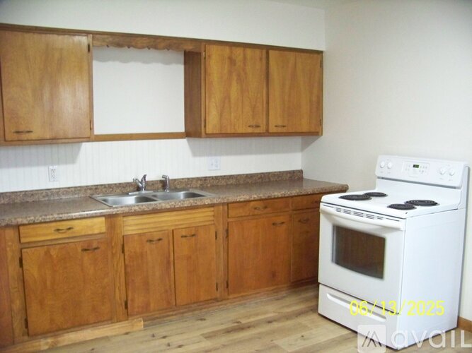 A kitchen with wooden cabinets and a white stove.