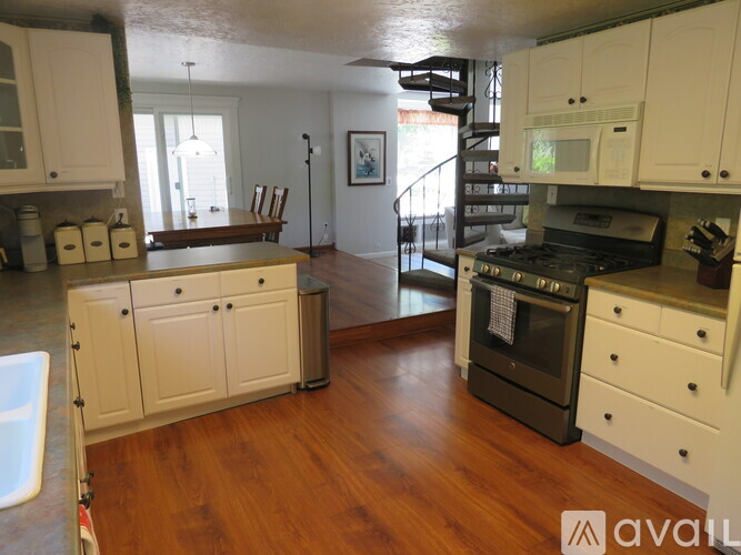 A kitchen with white cabinets and a black stove top oven.