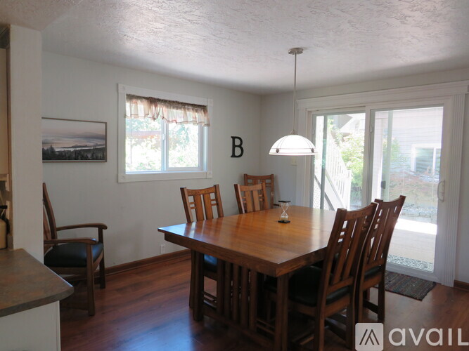 A dining room with a wooden table and chairs.