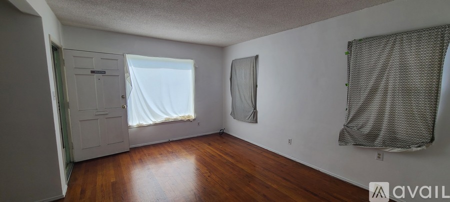 A room with a door, window, and a wall hanging.