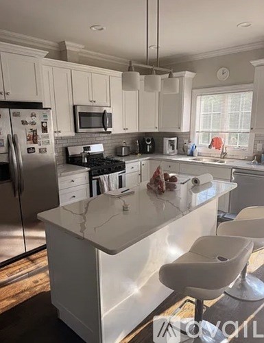 A white kitchen with a refrigerator, microwave, and oven.