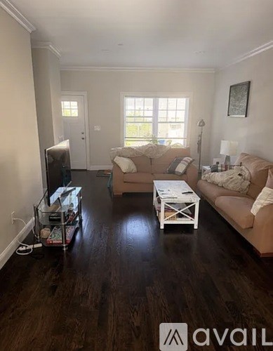 A living room with a white coffee table and a brown couch.