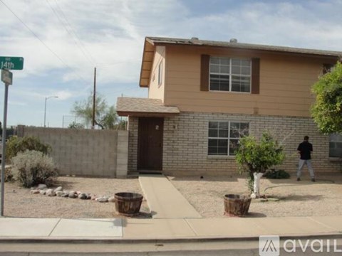 A house with a brown roof and tan siding is for sale.