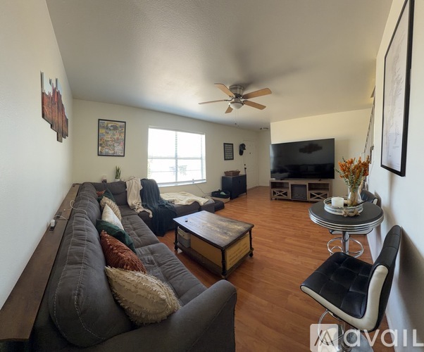 A living room with a grey couch and a wooden coffee table.