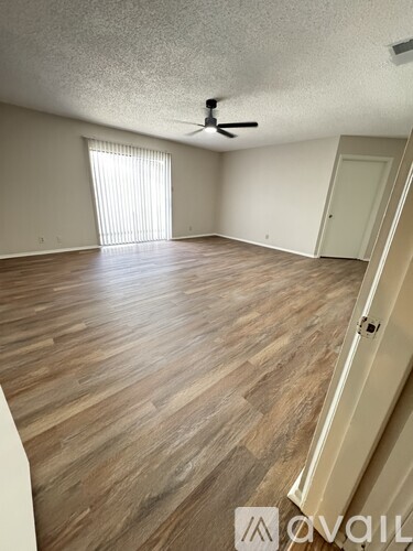 A room with wooden flooring and a ceiling fan.