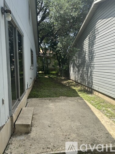 A white house with a concrete walkway leading to a door.