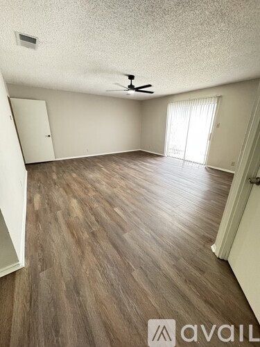 A room with wooden flooring and a ceiling fan.