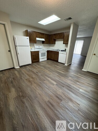 A kitchen with wooden cabinets and a white refrigerator.