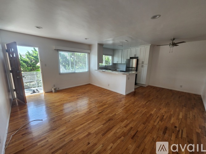 A room with wooden flooring and a ceiling fan.