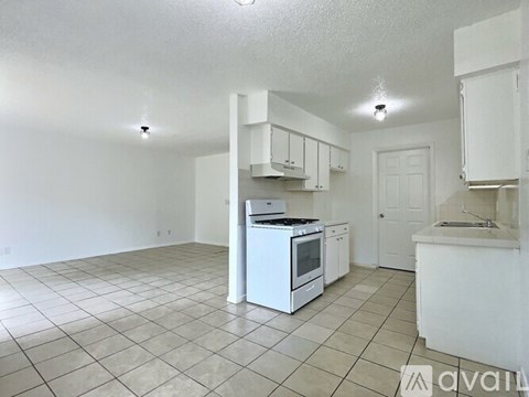 A kitchen with white appliances and cabinets is available for rent.