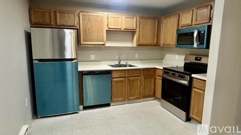 A kitchen with wooden cabinets and a blue refrigerator.
