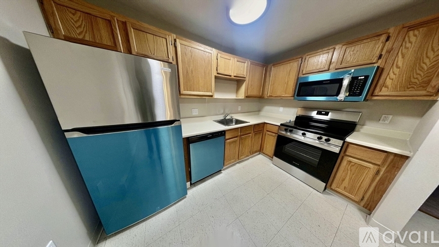 A kitchen with wooden cabinets and a blue refrigerator.