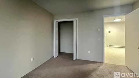 A room with a carpeted floor and a doorway leading to another room.