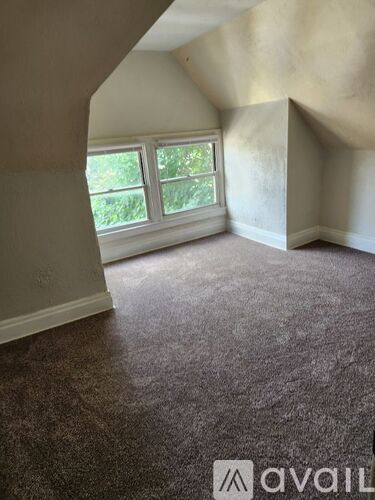 A room with a carpeted floor and a window.