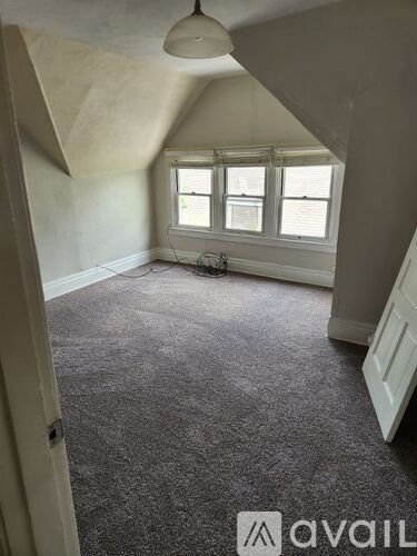 A room with a carpeted floor and a window.