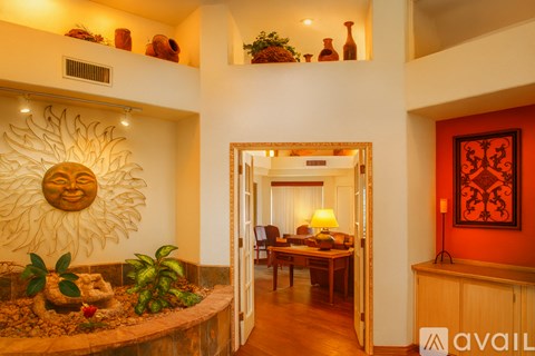 A sun design is on the wall above a planter.