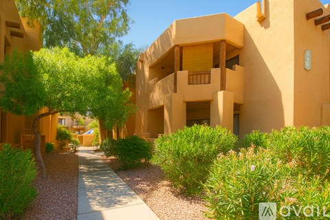 A pathway leads through a courtyard with a building on the right.