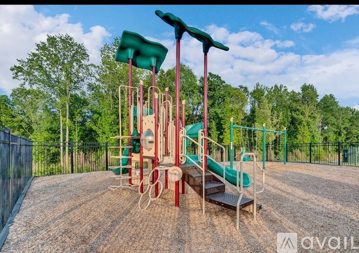 A playground with a green slide and red and green swings.