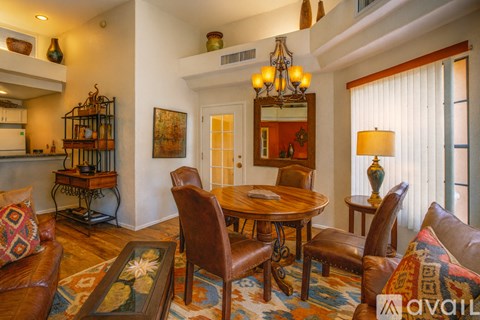 A living room with a brown leather couch and a wooden table.